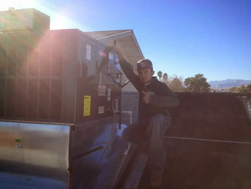 HVAC technician performing AC Tune-Up on a rooftop unit in Mound